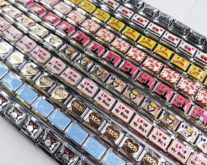 Macro shot of Italian modular stainless steel charm links with enamel icons and rhinestones