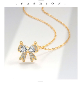 Macro-opname van gouden strikhanger met hartvormige zirkonia en fijne diamantzetting