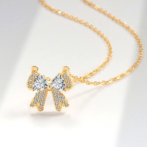 Elegante gouden strik ketting met hartvormige kristallen en fonkelende steentjes