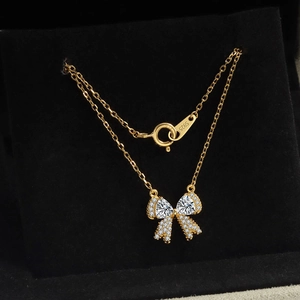 Elegante gouden strik hanger ketting met fonkelende strassteentjes op fluweel