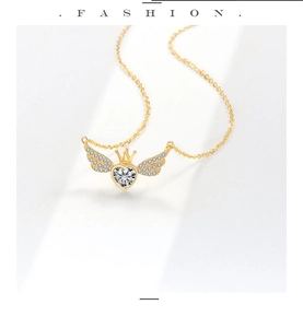 Detail van hartvormige hanger met gouden kroon en kristallen vleugels aan een gouden ketting