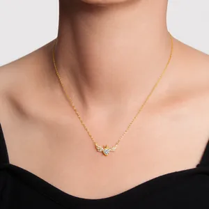Detail van de gouden hartketting met gevleugelde kroon hanger gedragen op een model