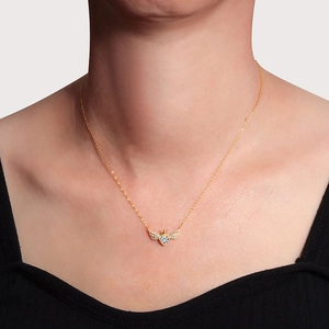 Gouden hart- en vleugelketting met kroon en zirkoon gedragen door een model