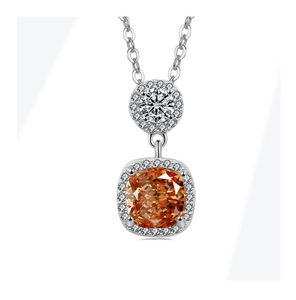 Macro detail of a silver necklace with cushion-cut orange gemstone and halo diamonds