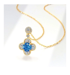 Dettaglio ravvicinato della collana con ciondolo a fiore dorato e pietra blu centrale