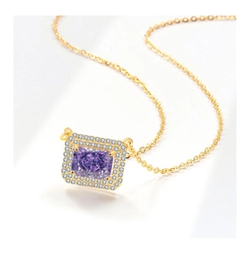 Macro view of a gold necklace featuring a rectangular purple gemstone with a halo of diamonds