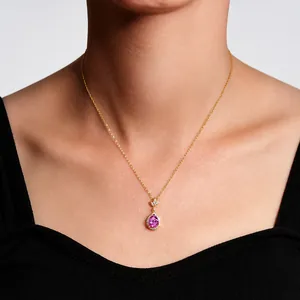 Close-up of golden necklace with pear-shaped purple gemstone and diamond leaf detail