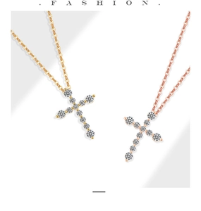 Detailansicht von Kreuzketten in Gold und Roségold mit funkelnden Zirkoniasteinen
