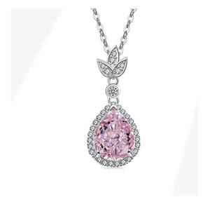 Dettaglio di una collana con pietra rosa a goccia e aureola di diamanti brillanti