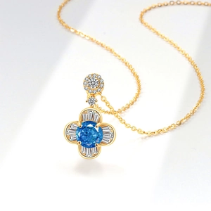Elegante collana con ciondolo a quadrifoglio in oro con gemma blu e diamanti baguette