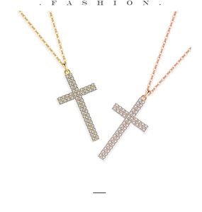 Nahaufnahme von Kreuzketten in Gold und Roségold mit funkelnden Zirkonia-Steinen