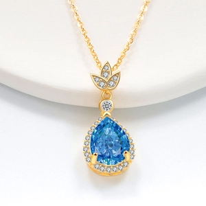 Collana con gemma blu a goccia montata in oro con piccoli cristalli bianchi e catena sottile