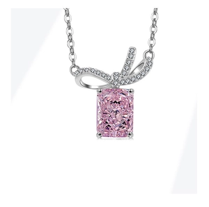 Macro detail of silver bow pendant with ice-cut pink rectangular gemstone and diamonds