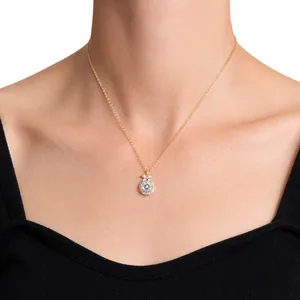 Close-up of S925 silver gold necklace with evil eye pendant and bow detail on a model