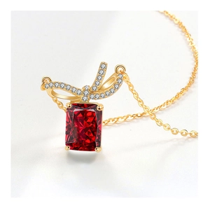 Macro view of a red rectangular gemstone pendant with a sparkling diamond bow accent