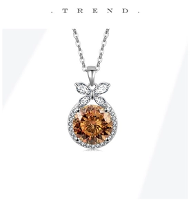 Macro view of S925 silver necklace featuring an orange stone and bow detail