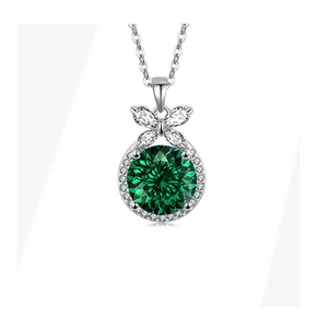 Macro shot of silver necklace with round green stone and butterfly accent