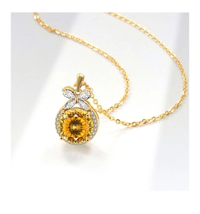 Detail of gold necklace with yellow faceted gemstone and butterfly motif pendant