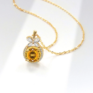 Elegant gold bow necklace with round yellow crystal gemstone and sparkling white diamonds