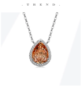 Detail of pear-cut champagne stone pendant with shimmering halo setting on silver chain