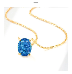 Detailed view of large oval blue gemstone pendant with golden chain on white background