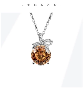 Detail van de strik-halsketting met ronde oranje edelsteen en micro-pavé kristallen