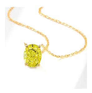 Macro view of luxury gold necklace featuring a large oval yellow gemstone with four-prong setting
