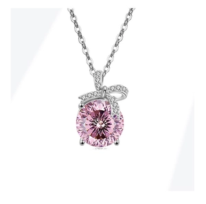 Detail van S925 zilveren ketting met roze steen en fonkelende strik hanger met zirkonia