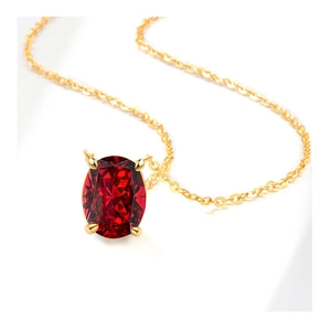 Macro view of a faceted oval ruby pendant in a four-prong gold setting on a fine chain