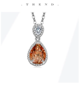 Macro view of teardrop halo pendant with orange and white pear-shaped zircon stones