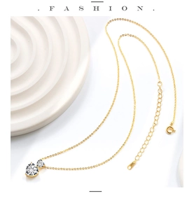 Detail of S925 hallmark on gold double heart pendant necklace with clear zircon stones