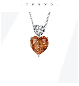 Detail of elegant silver double heart pendant featuring orange and white gemstones