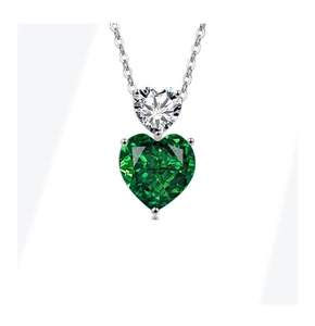 Detail of silver chain necklace with white and emerald green heart-shaped gemstones