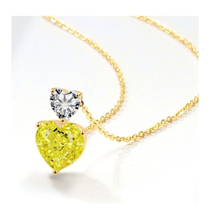 Macro shot of gold necklace with stacked white and yellow heart-shaped crystals