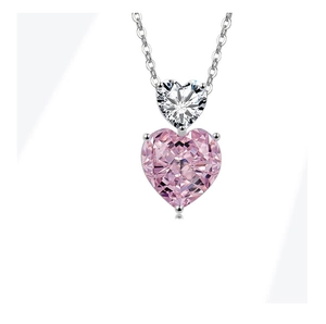 Detail of silver chain necklace with stacked white and pink heart-shaped crystal pendants