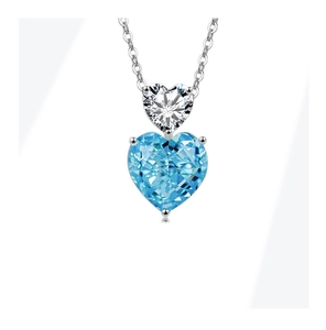 Macro detail of silver necklace featuring a double heart-shaped blue and clear gemstone pendant