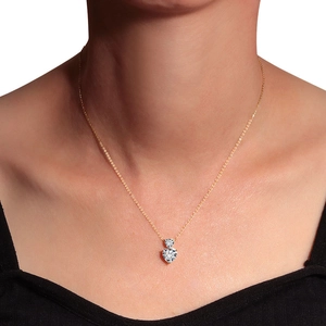 Golden necklace with heart and round crystals worn by a model in a centered shot