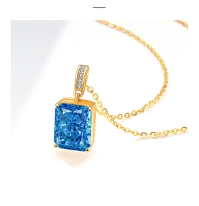 Detailed macro view of rectangle blue gemstone pendant on a gold chain necklace