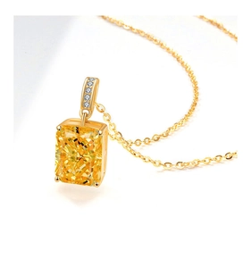 Macro shot of Radiant-cut yellow gemstone pendant with pave-set diamonds on gold chain