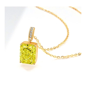 Macro shot of rectangular yellow gemstone pendant with gold chain on white background