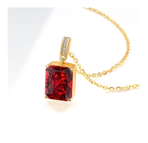 Macro detail of rectangle red ruby pendant with four-prong setting on gold chain necklace