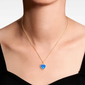 Detail einer herzförmigen blauen Edelsteinkette mit Diamanten auf goldener Kette