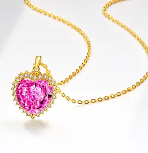 Makroaufnahme einer Kette mit rosa herzförmigem Edelstein und goldener Halskette