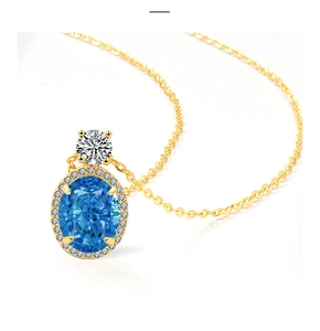 Détail d'un collier halo doré avec une pierre bleue ovale et une pierre ronde blanche