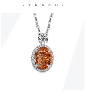 Détail d'un collier pendentif halo orange avec chaîne en argent et zircons blancs éclatants