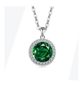 Macro shot of silver halo necklace featuring a faceted green gem and white pavé accents