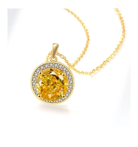 Macro shot of circular yellow gemstone pendant with white diamond halo on a gold chain