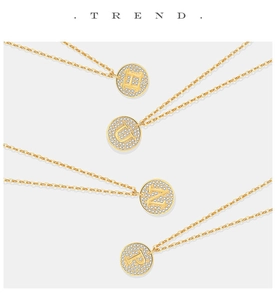Detail van vier gouden S925 zilveren kettingen met zirkonia letterhangers in close-up