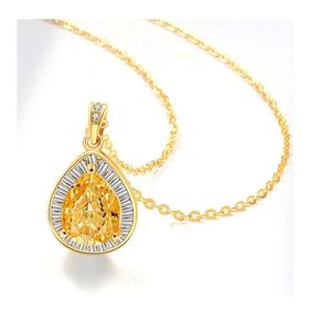 Macro di una collana a goccia dorata con zircone giallo e dettagli in piccoli cristalli