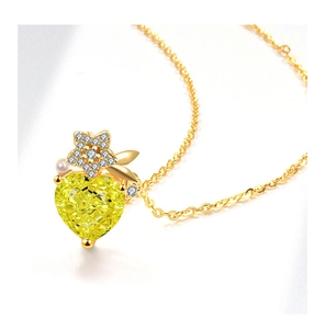 Detailed macro view of heart-shaped yellow gemstone pendant with star and pearl accents